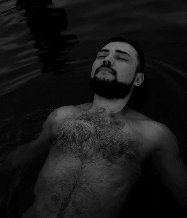 Person peacefully closing their eyes in a well-lit, serene room.